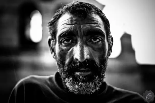 Retrato de um homem de barba, a preto e branco, a olhar de frente