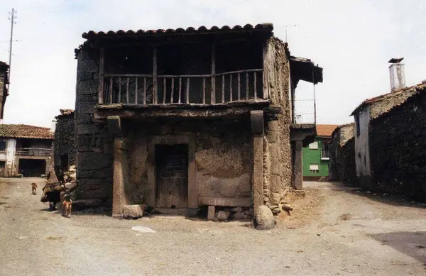 Casa de pedra de dois pisos com varanda de madeira corrida