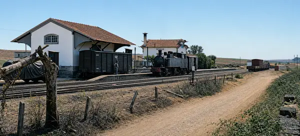 A estação com os vagões e o caminho de terra ao lado
