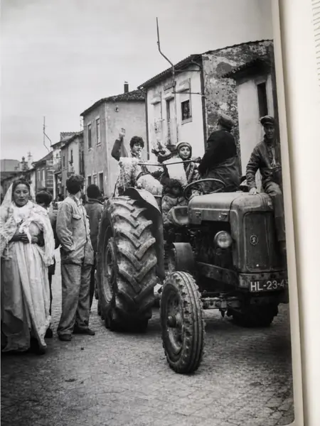 Um tractor a subir a rua, com crianças em cima