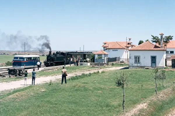 A estação com o comboio e uma camioneta azul parada
