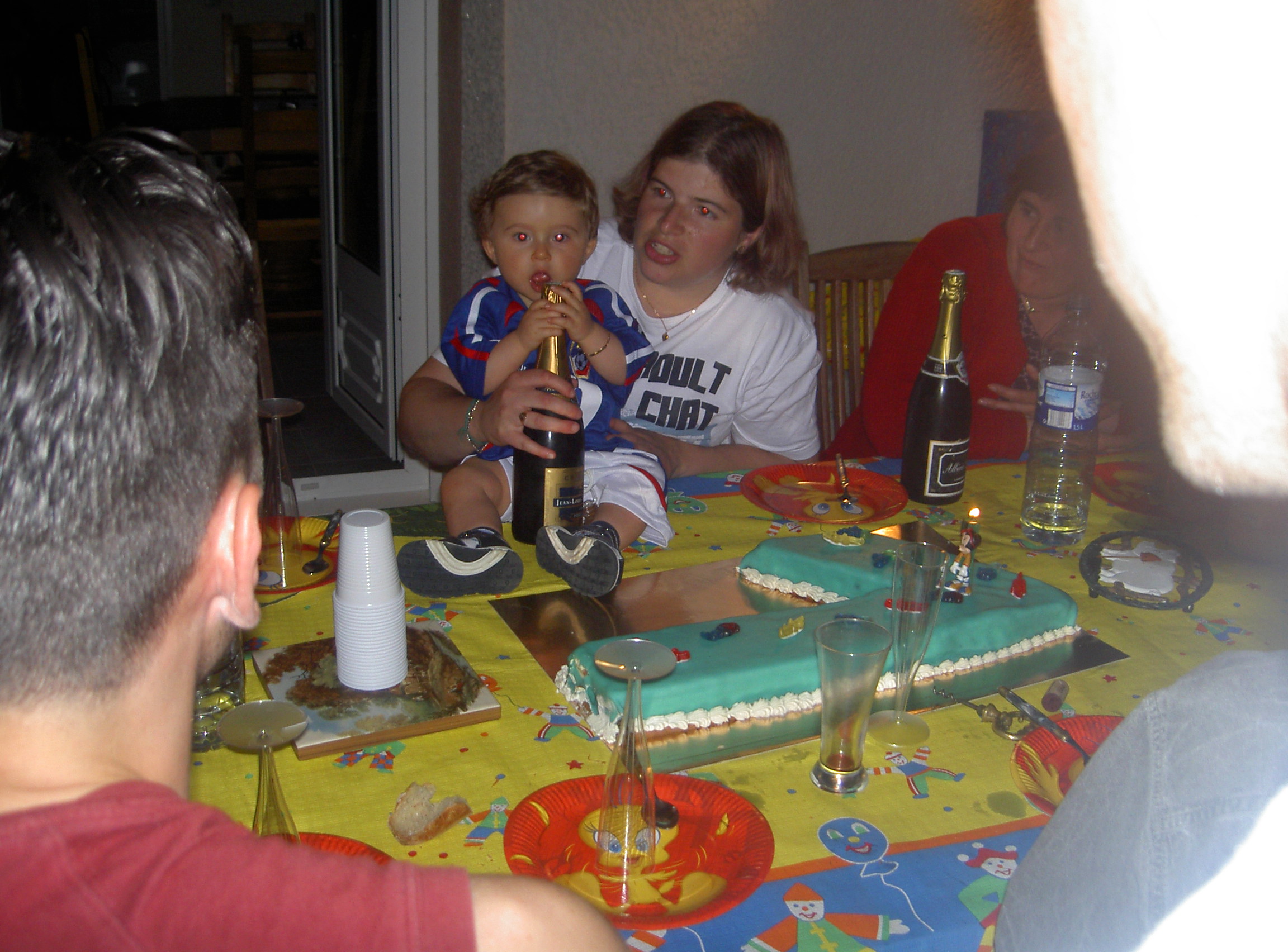 O meu neto garrafa de champagne na mao e pronto para soprar a vela de 1 ano.